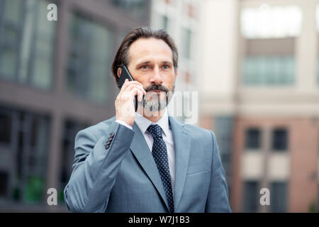 Businessman wearing tie calling his business partner Stock Photo
