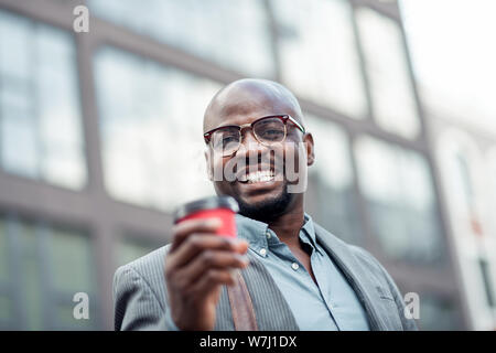 African-American office worker smiling and drinking coffee Stock Photo