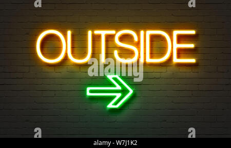 Outside neon sign on brick wall background Stock Photo