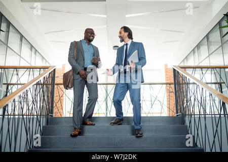 Two businessmen going down the stairs while having lunch break Stock Photo