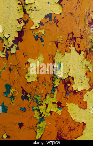 rusty metal sheet with peeling layers of paint of different colours - a surface texture photo Stock Photo