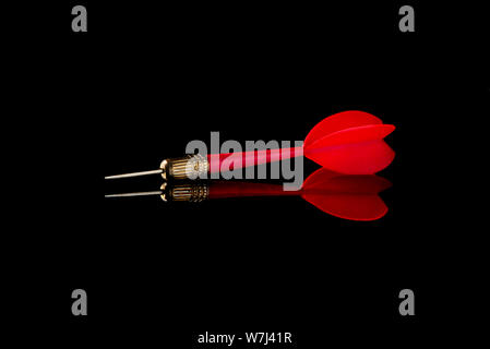 Red dart on a black background. Hit the target. Stock Photo