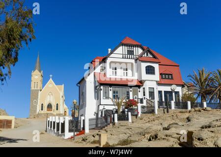 Half-timbered house from German colonial times and rock church in the old town of Luderitz, Namibia Stock Photo