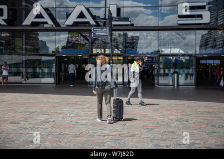 Rotterdam Netherlands, July 1st, 2019. Rotterdam Centraal, Central station building facade and entrance. Young woman with luggage entering the station Stock Photo