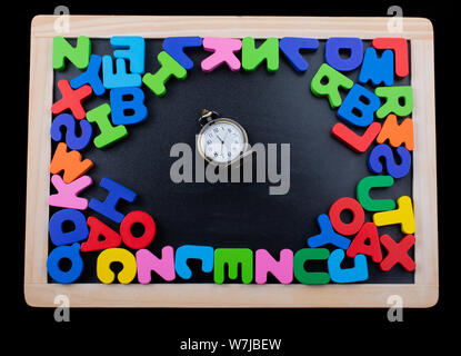 Pocket watch and colorful Letters of Alphabet made of wood Stock Photo