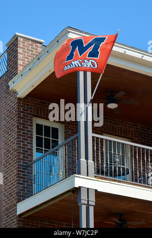 An 'Ole Miss' banner blows in the wind from a balcony in downtown Oxford, near the University of Mississippi in Oxford, MS Stock Photo