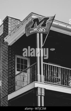 An 'Ole Miss' banner blows in the wind from a balcony in downtown Oxford, near the University of Mississippi in Oxford, MS Stock Photo