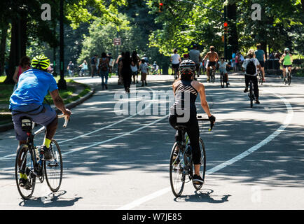 People biking and wlaking around Central Park New York City on a sunny day. Stock Photo