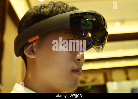 A visitor tries out HoloLens smartglass with mixed reality of Microsoft during a new product experience event in Hangzhou city, east China's Zhejiang Stock Photo