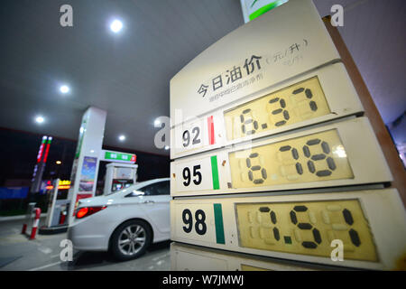 --FILE--A car is being refueled next to a display showing fuel prices at a gas station of Sinopec in Shanghai, China, 14 December 2016.   China is joi Stock Photo