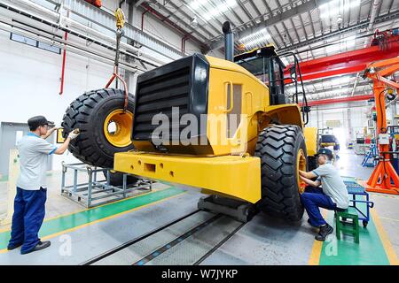 --FILE--Chinese workers produce electric products on the assembly line ...