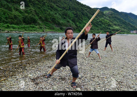 A Chinese villager of Miao ethnic group wearing traditional costumes  practises ''Miao stickfighting'', a unique martial art of the Miao Martial  Arts i Stock Photo - Alamy