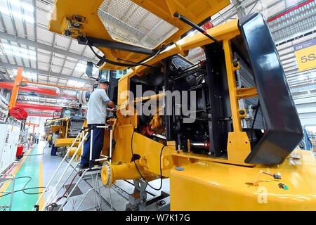 --FILE--Chinese workers produce electric products on the assembly line ...