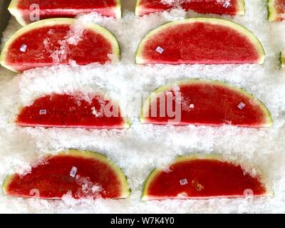 Watermelon fruit slices on ice. Cold fresh summer fruit background. Stock Photo