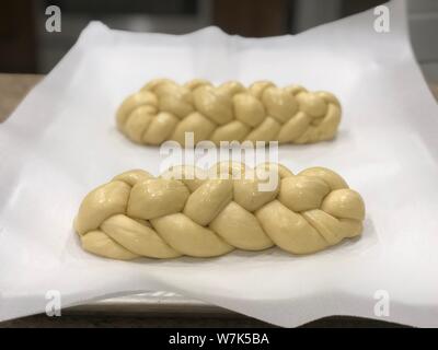 Backing homemade Challah bread braided dough before its baked on a backing paper Stock Photo
