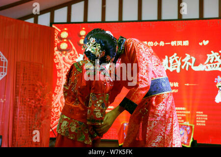 42-year-old Chinese bridegroom Li Haimin dressed in traditional costumes, right, who is 4 foot 8 inches tall, kisses his wife 38-year-old Fei Yongling Stock Photo