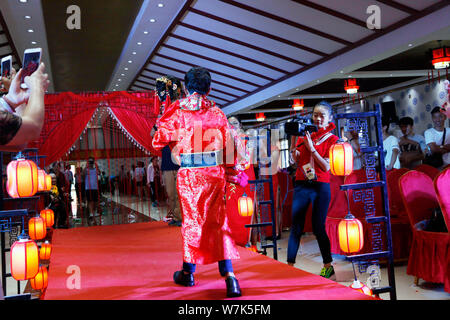 42-year-old Chinese bridegroom Li Haimin dressed in traditional costumes, right, who is 4 foot 8 inches tall, holds his wife 38-year-old Fei Yongling, Stock Photo