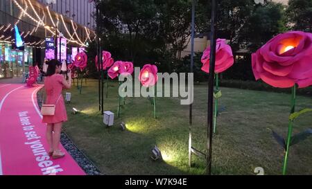 A customer takes photos of pink installations on display at the ...