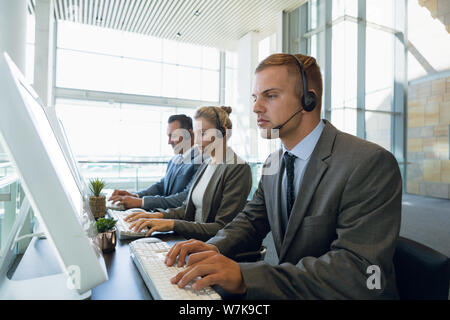 Business people working together on computer at desk Stock Photo