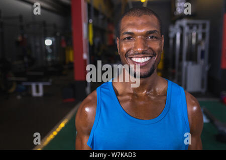 Male athletic looking at camera while standing in fitness center Stock Photo