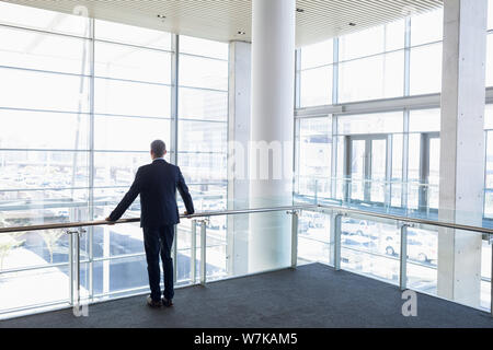 Back view of businessman looking out of office window Stock Photo