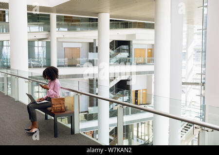 Young businesswoman working in a business lobby Stock Photo