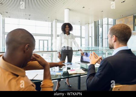 Young businesswoman presenting to colleagues Stock Photo