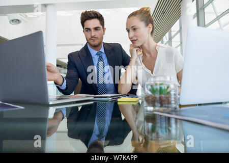 Two young business people working together in office Stock Photo