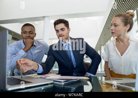 Diverse young business colleagues working together at desk Stock Photo
