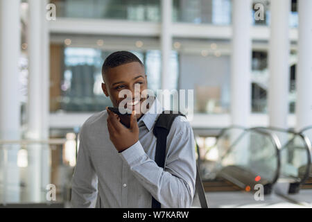 Businessman using smartphone in modern building Stock Photo