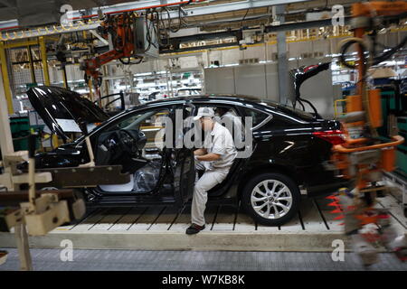 --FILE--A Chinese worker assembles a car on the assembly line at an ...