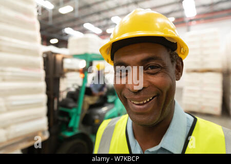 Happy male worker looking at camera in warehouse Stock Photo