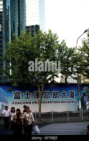 --FILE--Pedestrians walk past the Foxconn headquarters building under construction in Pudong district, Shanghai, China, 3 October 2014.   Taiwan's ele Stock Photo