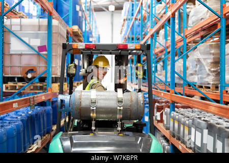 Female staff driving forklift in warehouse Stock Photo