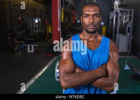 Male athletic standing with arms crossed in fitness center Stock Photo