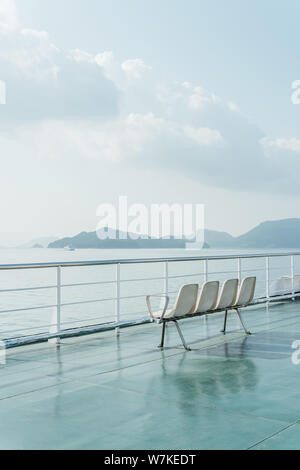 Minimal view over beautiful Shikoku island landscape on ferry deck with mountains, the sea and a ship in the background while traveling from Takamatsu Stock Photo