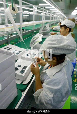--FILE--Chinese workers produce electric products on the assembly line ...