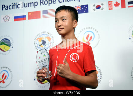 Cen Xiaolin, a 13-year-old boy from south China's Guangdong, poses with his trophy after winning the champion during the Asia and Pacific Jump Rope Ch Stock Photo