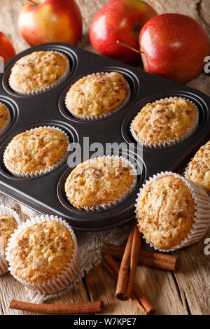 Fresh apple muffins with cinnamon close-up in a tray on the table. vertical Stock Photo