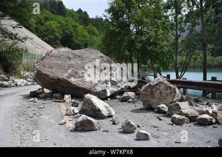 A road is damaged by rubbles from a landslide after the 7.0-magnitude earthquake in Jiuzhaigou County, Ngawa Tibetan and Qiang Autonomous Prefecture, Stock Photo