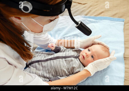 Female nurse examining cute little kid Stock Photo