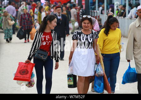 Chinese Muslims leave after shopping for goods at the market on the Bazar Day (Market Day) ahead of the Eid al-Adha, also called the 'Sacrifice Feast' Stock Photo