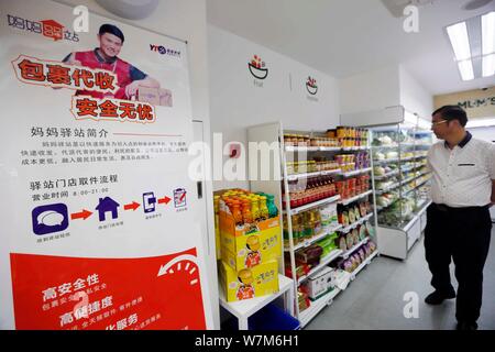 A Chinese pedestrian walks into MUM'S SELECTION, the express convenience  store of Yuantong Express Delivery Co. Ltd., at Putuo District in Shanghai,  C Stock Photo - Alamy