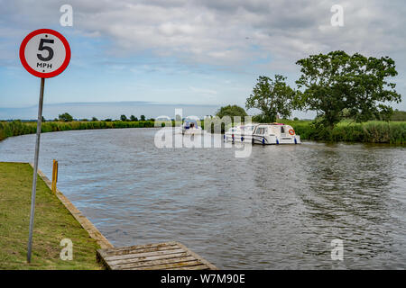 A 5mph speed limit sign on the bank of the River Bure in Horning. Speed limit signs are prevalent along the rivers of the Norfolk Broads, and whilst c Stock Photo
