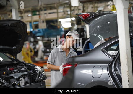 --FILE--A Chinese worker assembles a car on the assembly line at an ...