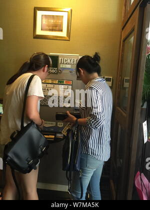 Japanese customers operate a ramen ticket machine at a Lanzhou beef hand-pulled noodle restaurant of Mazilu Beef Noodles in Chiyoda, Tokyo, Japan, 24