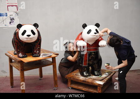 --FILE--Chinese artists paint one of the two life-size lacquerware giant pandas in Chengdu city, southwest China's Sichuan province, 16 June 2017.   C Stock Photo