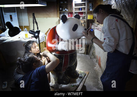 --FILE--Chinese artists paint one of the two life-size lacquerware giant pandas in Chengdu city, southwest China's Sichuan province, 16 June 2017.   C Stock Photo