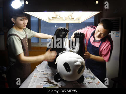 --FILE--Chinese artists paint one of the two life-size lacquerware giant pandas in Chengdu city, southwest China's Sichuan province, 31 May 2017.   Ch Stock Photo