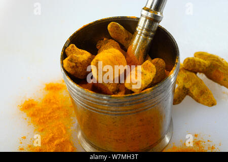 Turmeric roots in mortar and pestle Stock Photo
